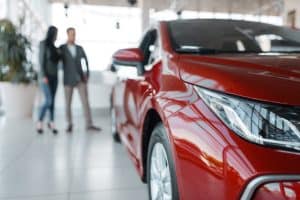 couple-buying-new-red-car-in-showroom-2021-08-26-16-26-21-utc-scaled